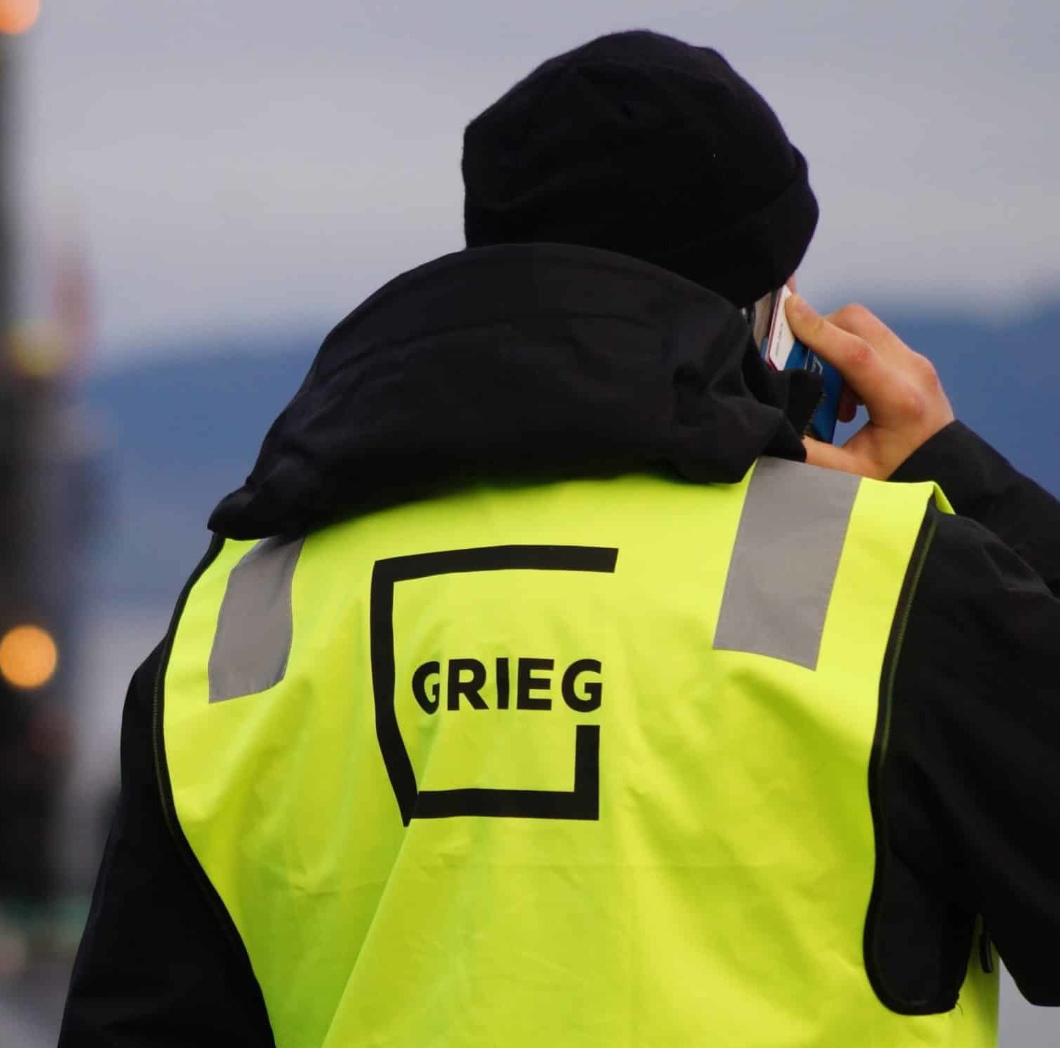 A male worker wearing a Grieg reflective vest.