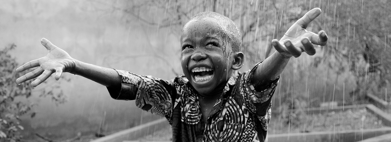 Happy child dancing in the rain.
