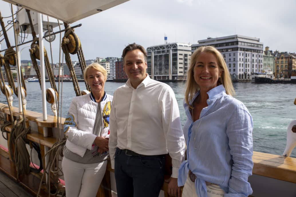 Matt Duke, Elisabeth Grieg and Camilla Grieg smiling on a boat.