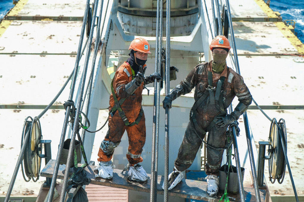 Two workers from G2 Ocean on the deck of a vessel.