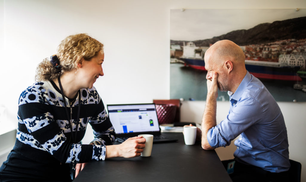 Two employees having a coffee at a meeting in the office.