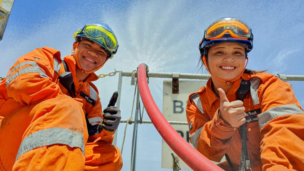 Two employees in uniforms, giving thumbs up.